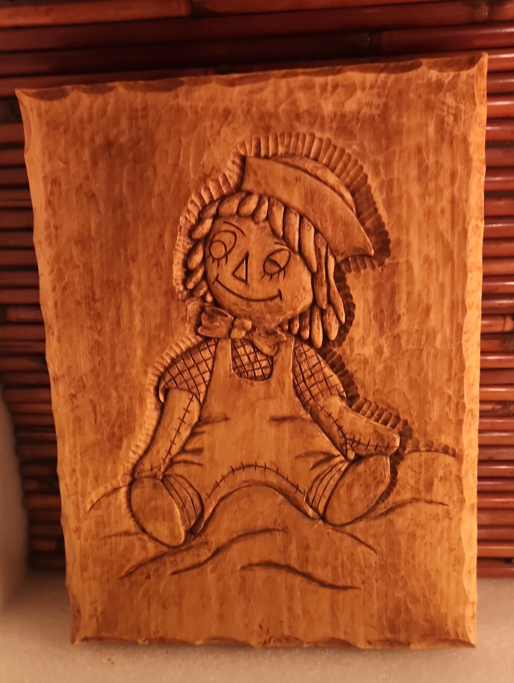 hand-carved wooden plate depicting the character Raggedy Andy